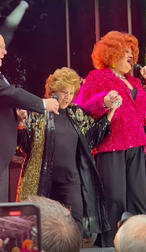 a woman in a pink jacket stands next to two other women