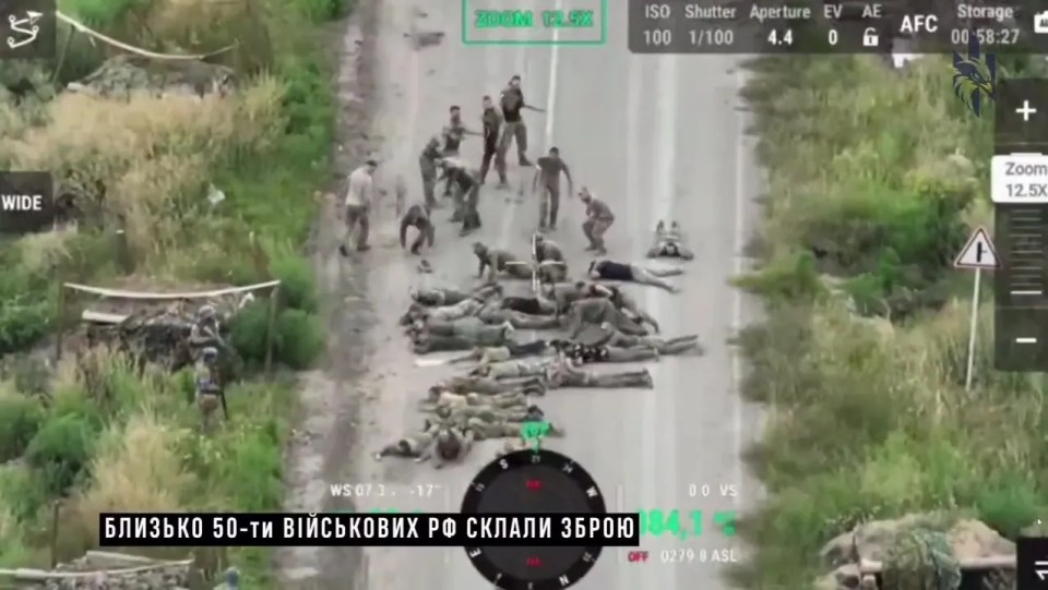 Russian soldiers lay on a road after surrendering their weapons after the blitz invasion