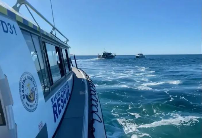 a boat with the word rescue on the side is floating on top of a body of water .