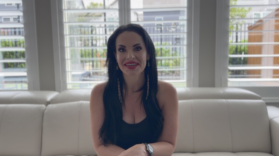 a woman sits on a white couch with her arms crossed