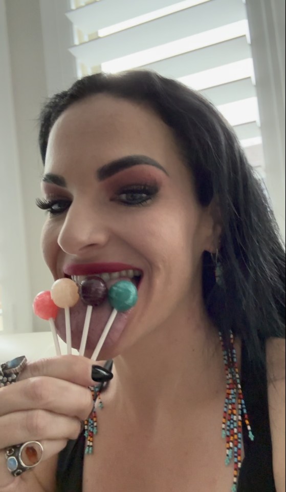 a woman with a ring on her finger is eating lollipops