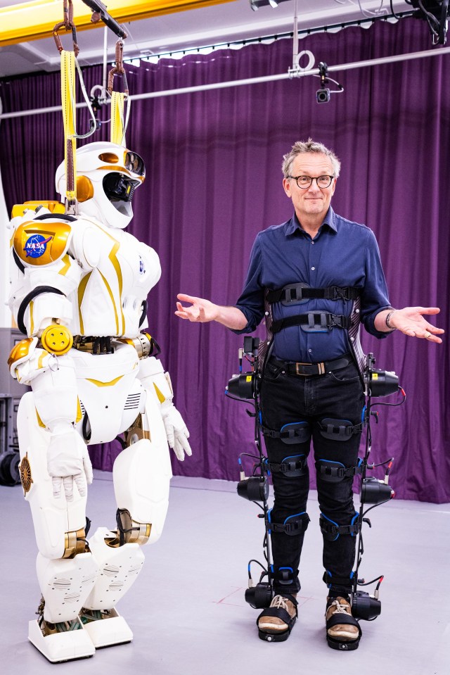 a man standing next to a nasa robot