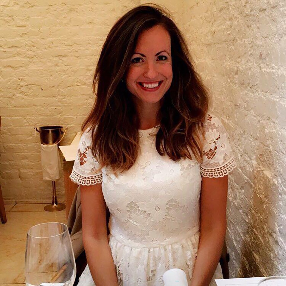 a woman in a white lace dress smiles for the camera