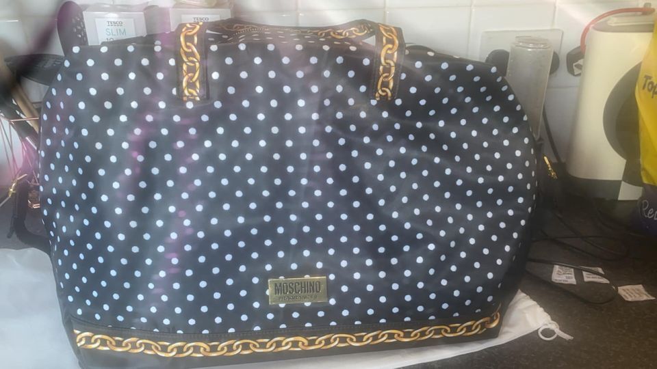 a black and white polka dot moschino bag with gold chains