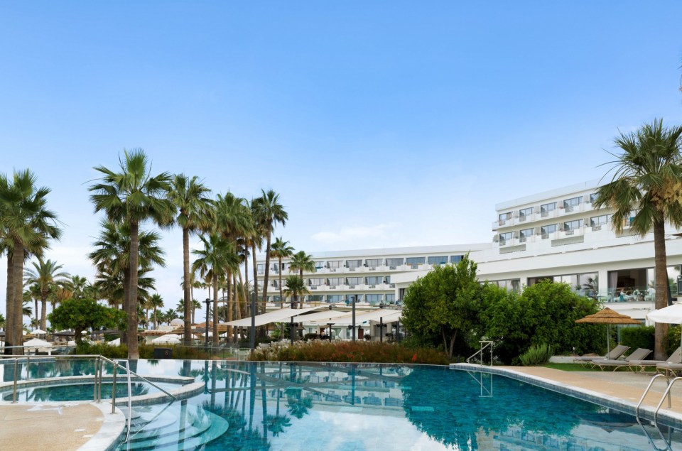 a large hotel with a swimming pool in front of it