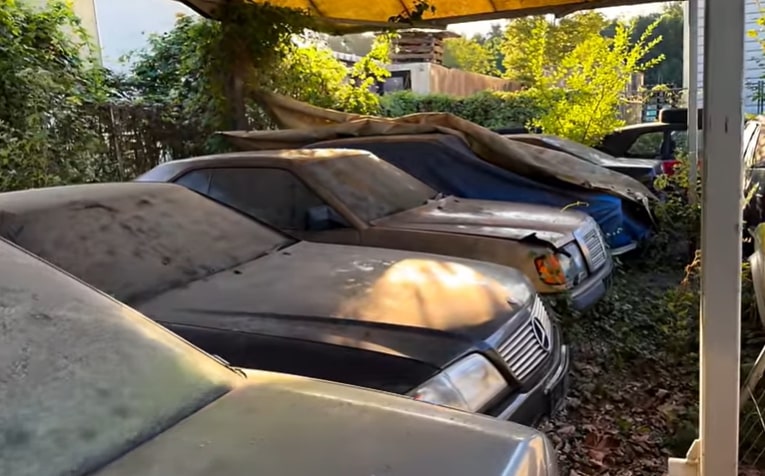 a row of old cars are parked under a canopy