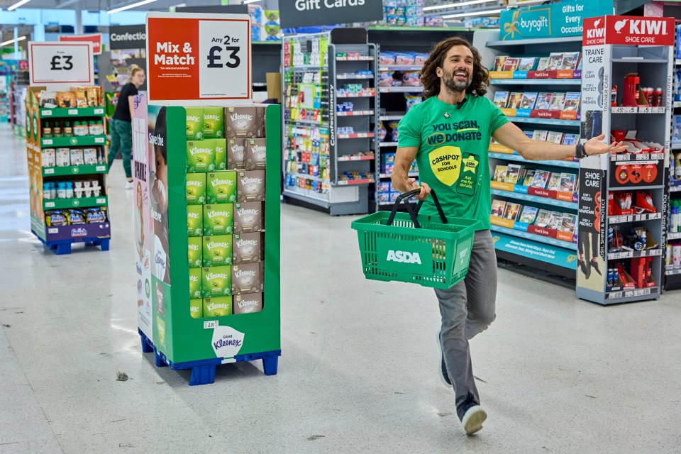 a man in a green shirt carrying an asda basket