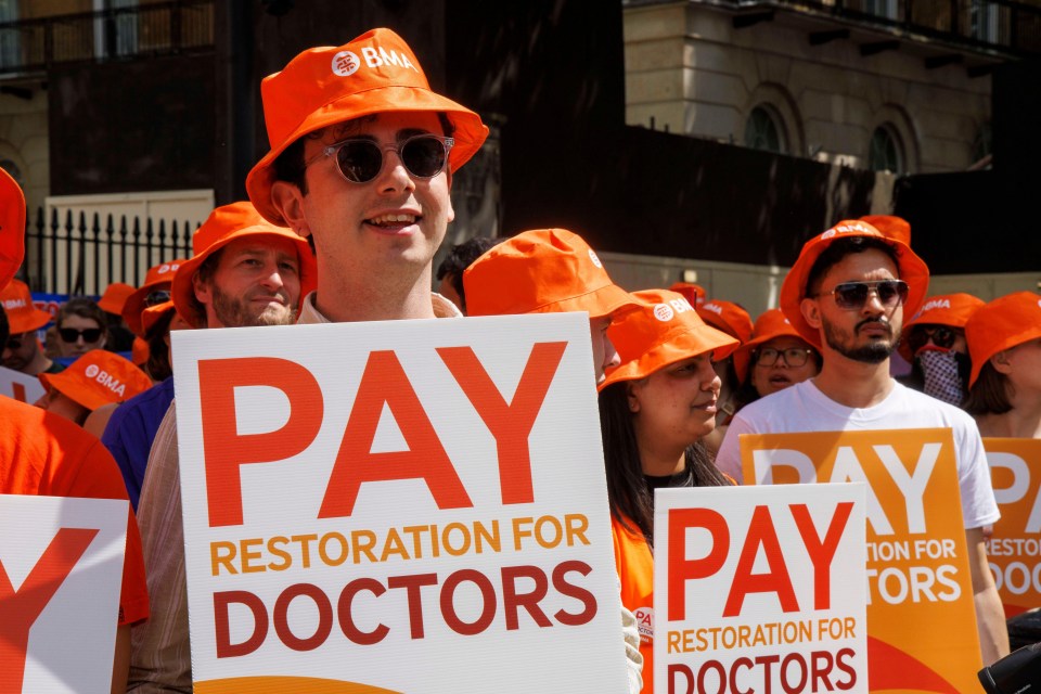 a man holding a sign that says pay restoration for doctors