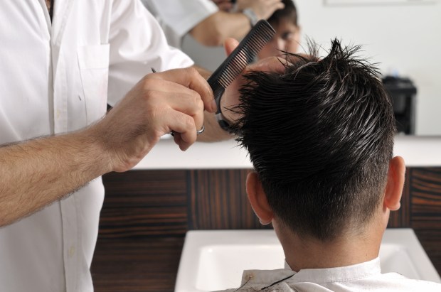 a man is getting his hair cut by a barber