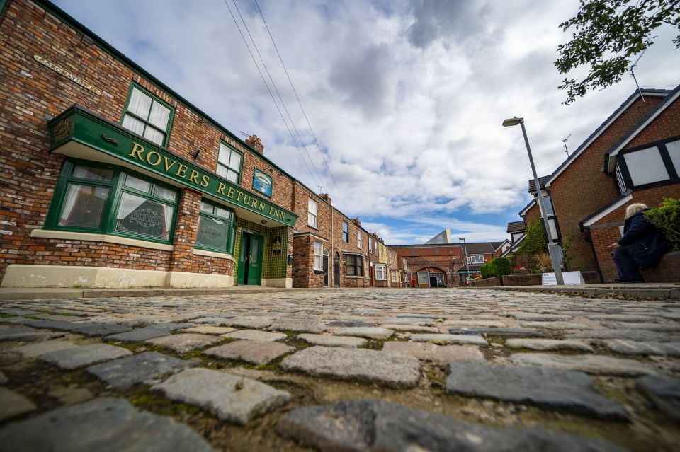 a brick building with a green sign that says rovers return inn