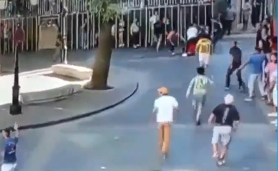 a group of people are running down a street in front of a fountain