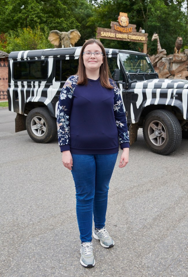 a girl stands in front of a safari drive through sign