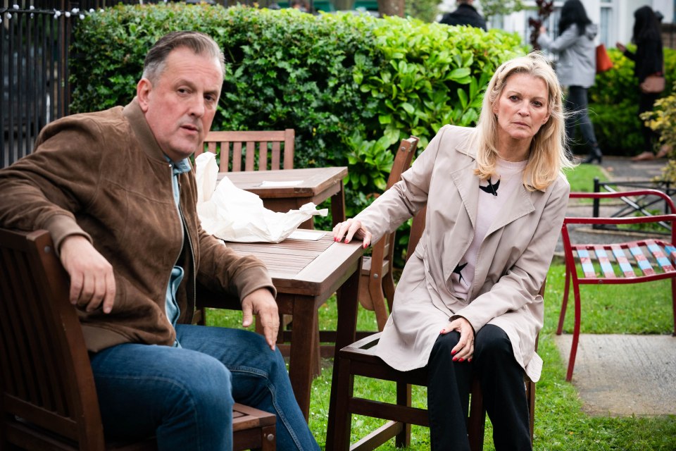 a man and a woman sit at a table with drinks