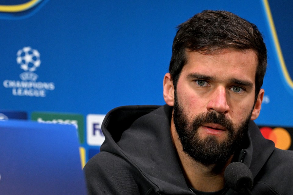 a man with a beard stands in front of a champions league sign