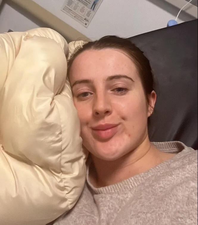 a woman in a hospital bed with a thank you sign on the wall