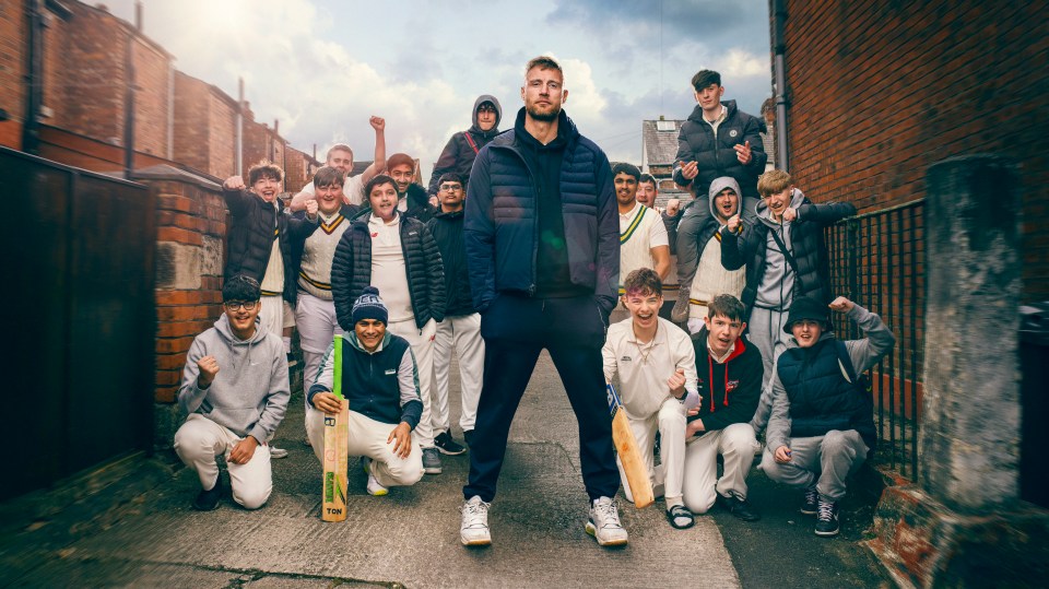 a group of young men are posing for a picture and one of them is holding a cricket bat