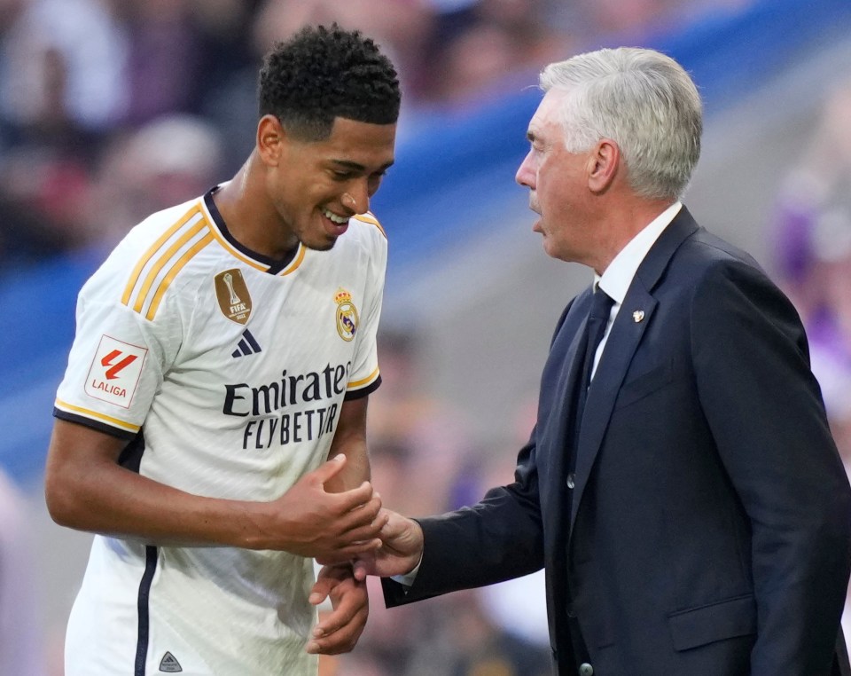 a soccer player wearing an emirates jersey shakes hands with an older man