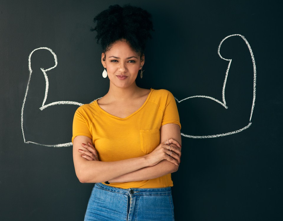 a woman stands in front of a blackboard with a drawing of two muscles drawn on it