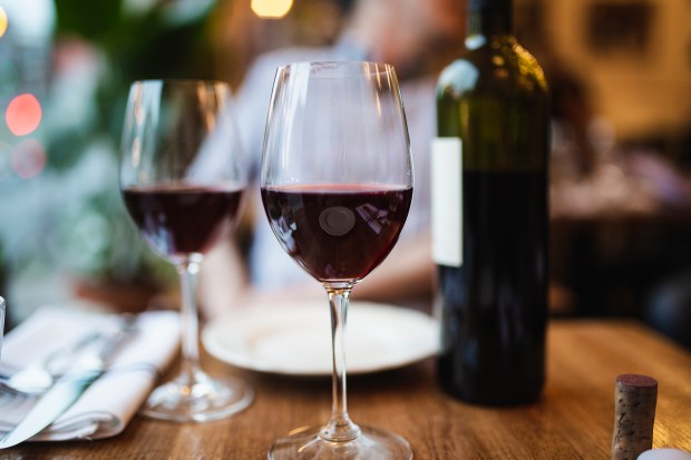 a bottle of wine sits on a table next to two glasses of wine