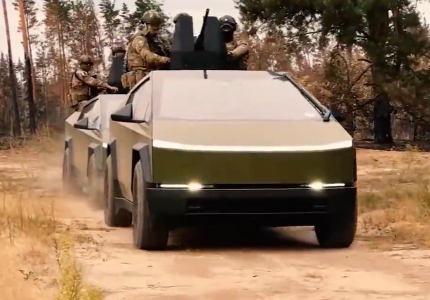 a military vehicle is driving down a dirt road