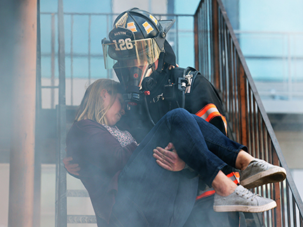 a fireman carrying a woman with the number 126 on his helmet