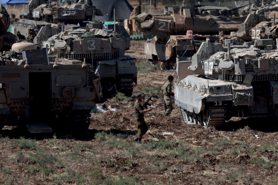 Israeli soldiers man tanks at a gathering point in northern Israel on Saturday