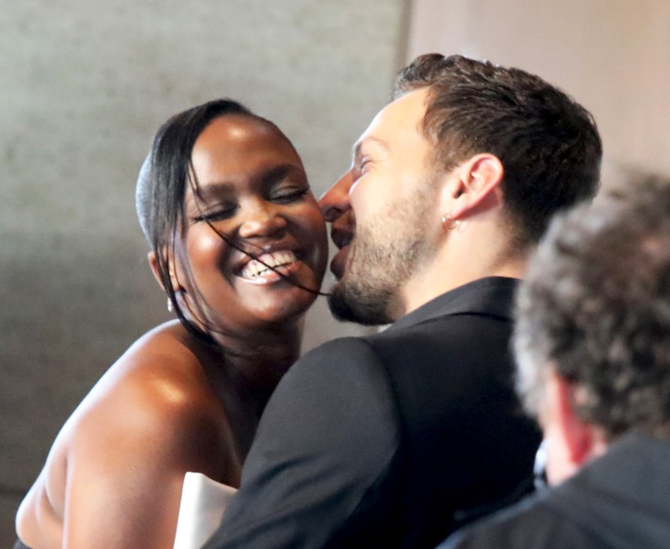 a man and a woman are touching noses and smiling