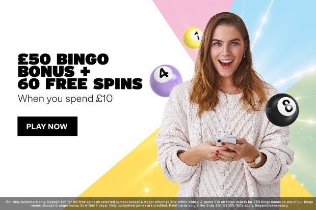 a woman is holding a cell phone in front of a sign that says 50 bingo bonus + 60 free spins when you spend £ 10