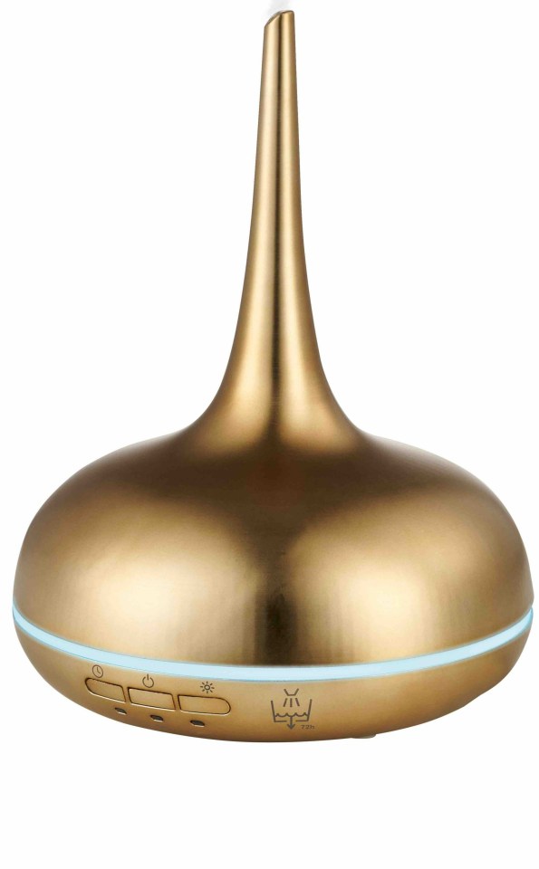 a gold colored ultrasonic diffuser with smoke coming out of it