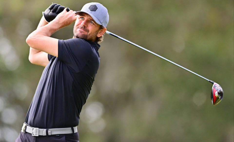 a man swings a golf club on a golf course