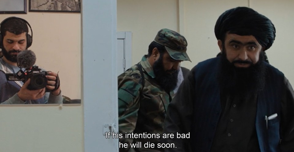 Ibrahim Nash'at, far left, filming a scene in a dormitory room at the US base, Taliban members on the right