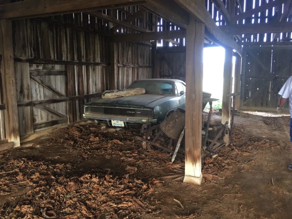 an old dodge charger is parked in a barn