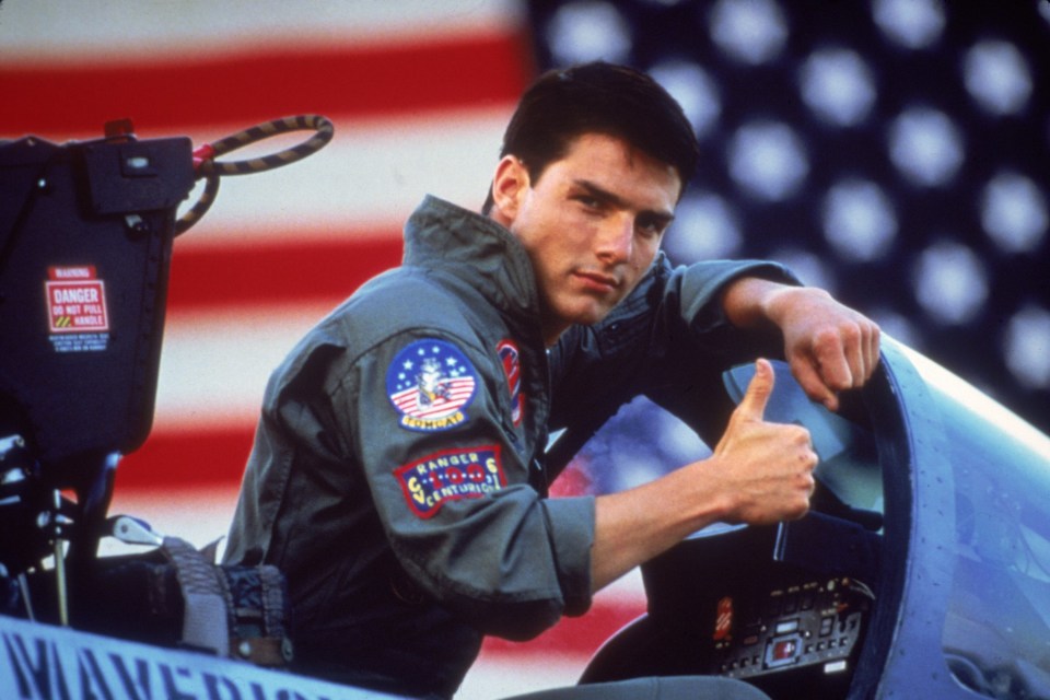 a man giving a thumbs up in front of an american flag