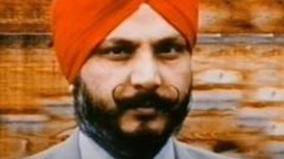 a man with a beard wearing an orange turban