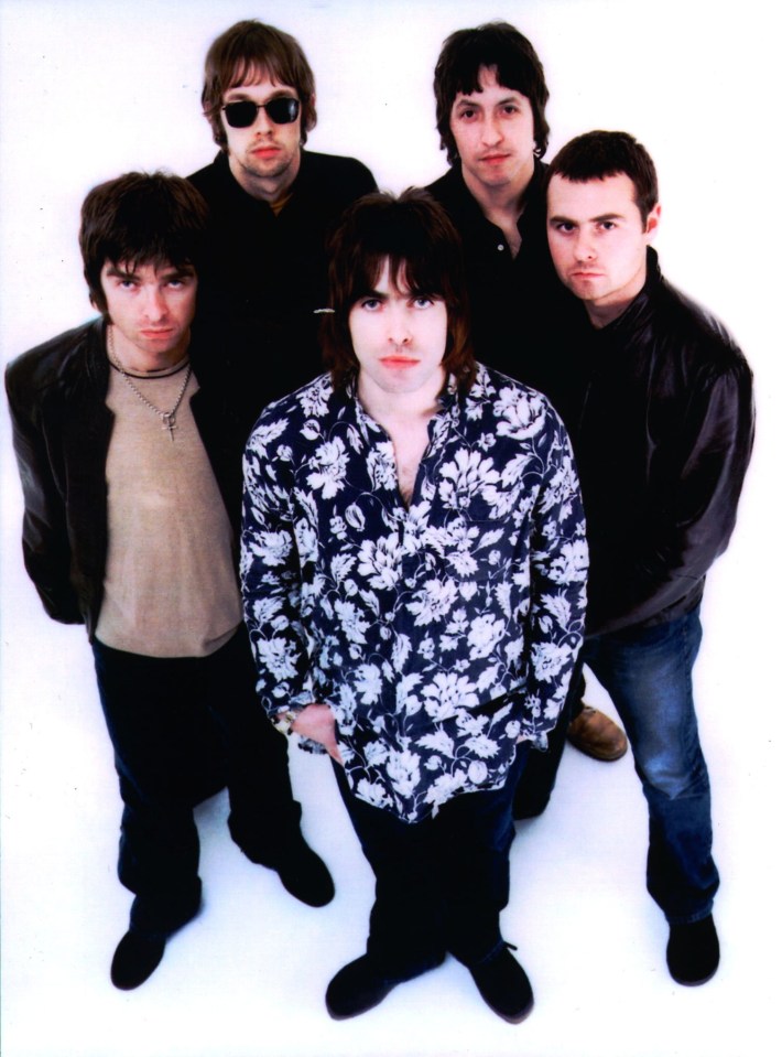 a group of men posing for a picture with one wearing a floral shirt