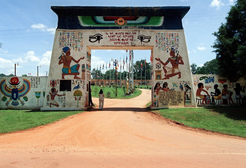 A clay road leads from the main road to the entrance of the Nuwaubian complex where a white pylon painted with Egyptian hieroglyphics rises from the red clay