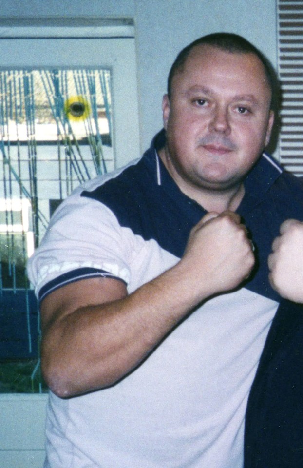 a man in a blue and white shirt has his fist in the air