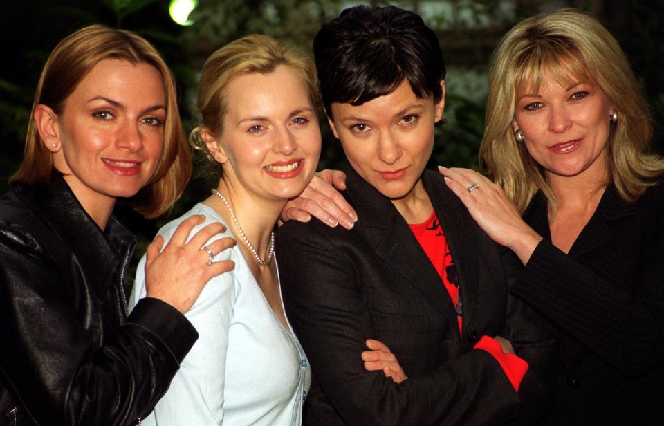 four women are posing for a picture and one has a ring on her finger