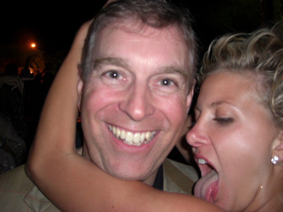 a man and a woman are posing for a picture and the woman is sticking her tongue out