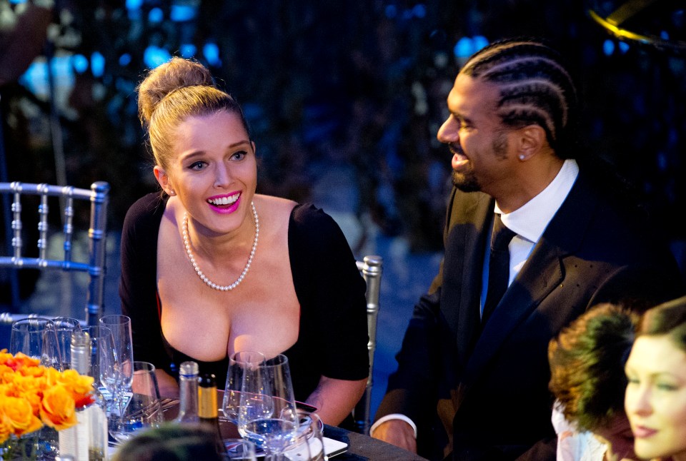 a woman in a pearl necklace sits next to a man in a suit