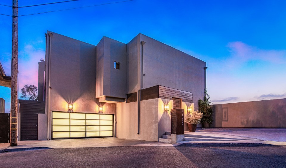 the front of a modern house with a large garage door