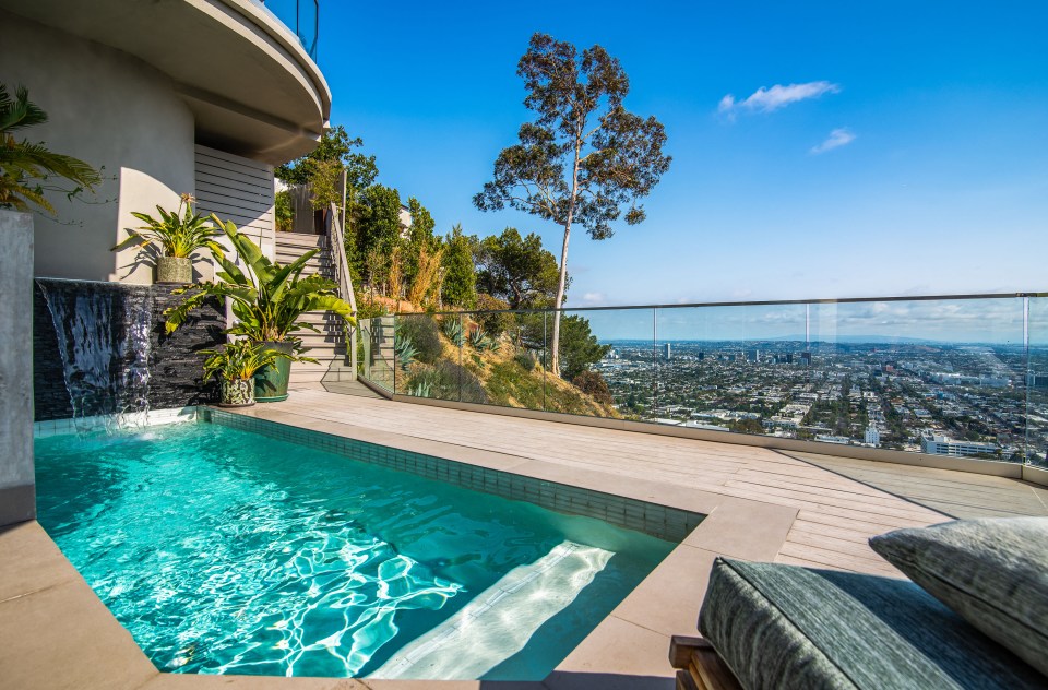 a swimming pool on a balcony overlooking a city