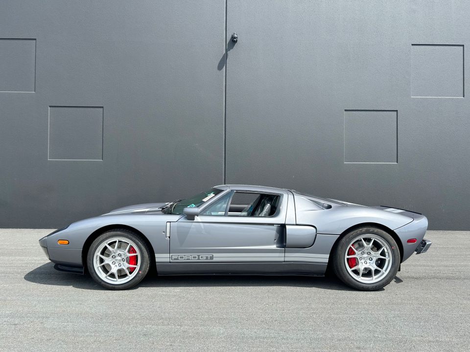 a silver ford gt is parked in front of a building