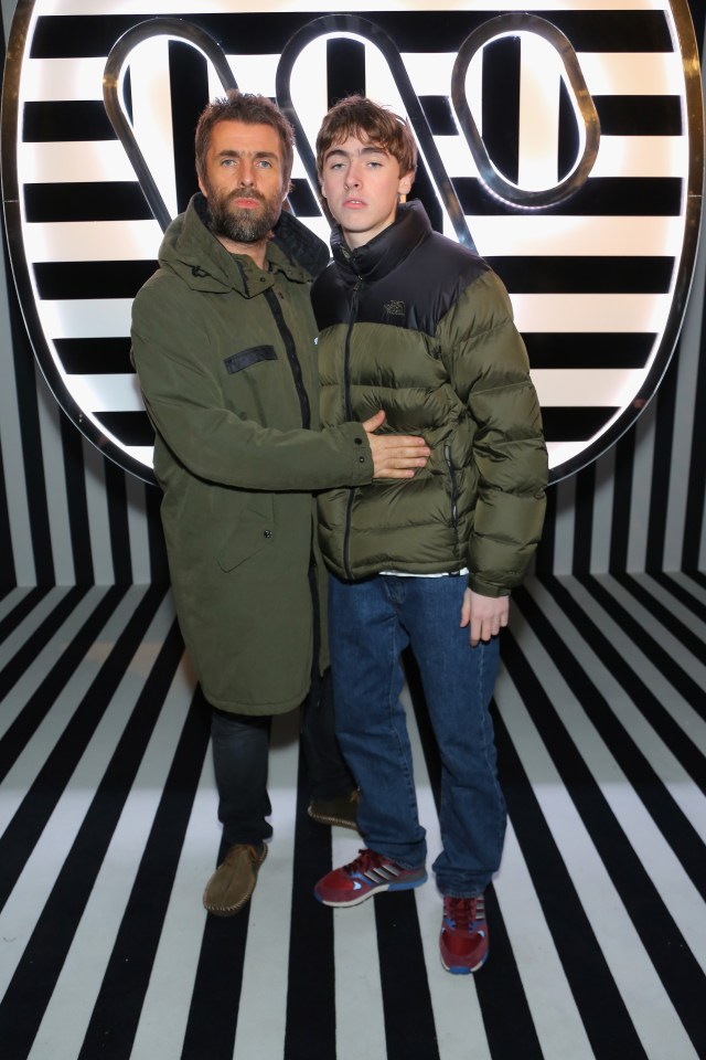 a man and a boy are posing for a picture in front of a sign that has the letter o on it