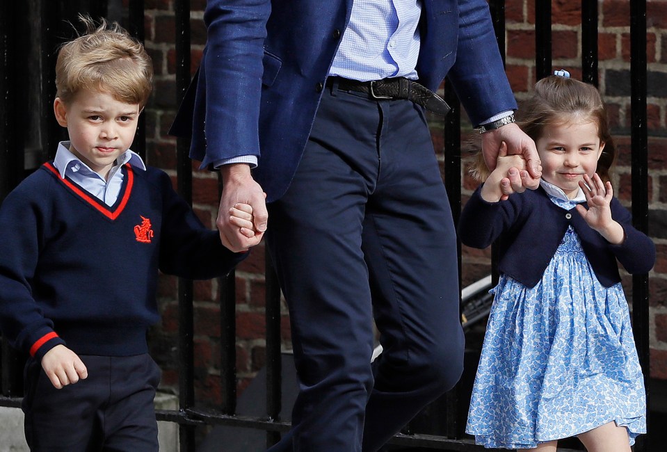 a little girl in a blue dress is holding a man 's hand