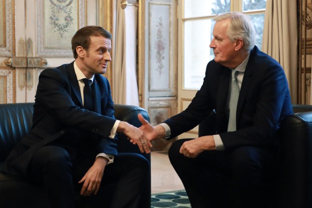 two men are sitting on a couch and shaking hands