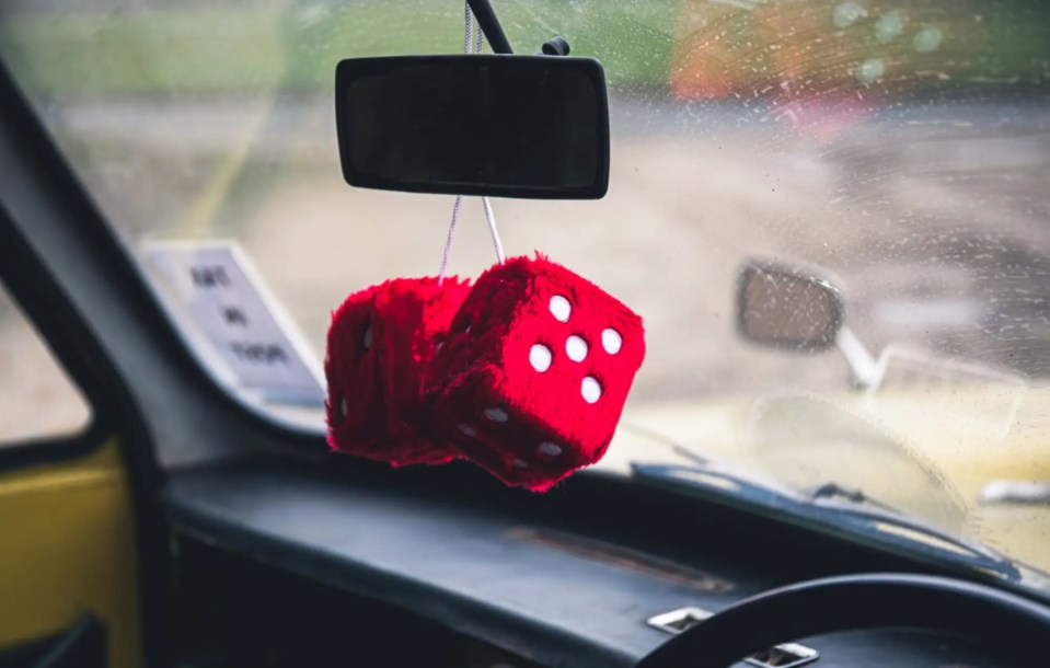 Fluffy dice hanging from the car's rear-view mirror