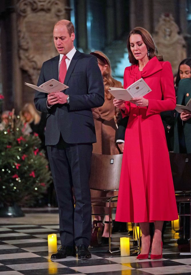 a man in a suit and tie stands next to a woman in a red dress