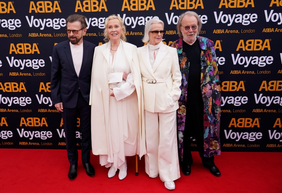 a group of people standing in front of a wall that says voyage