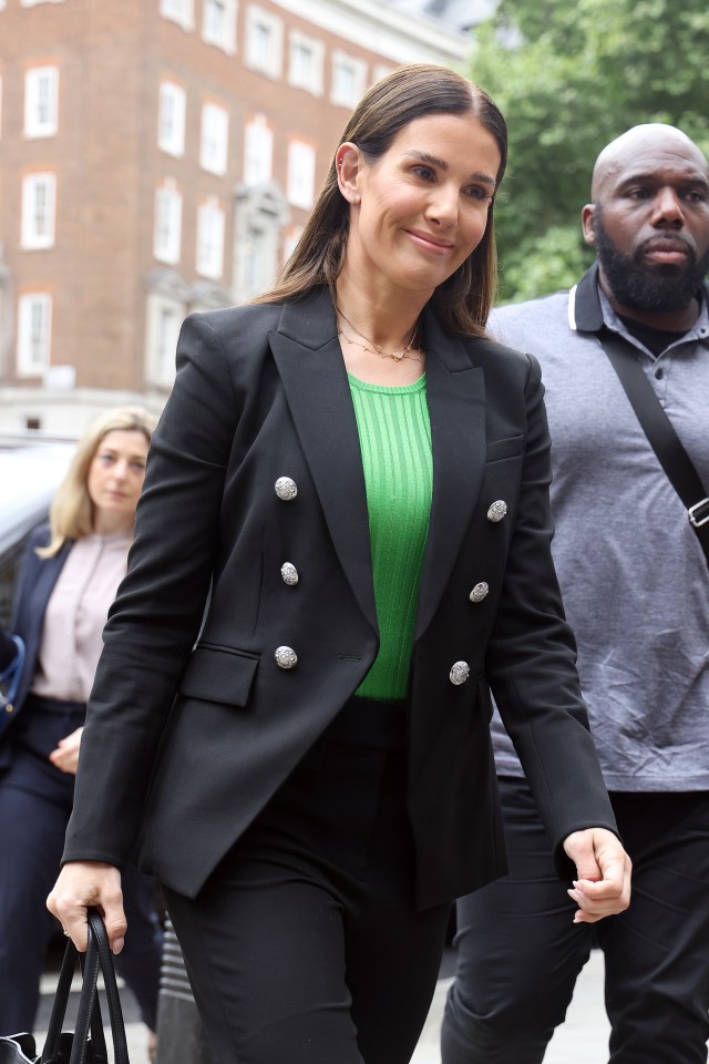 a woman wearing a green top and a black jacket